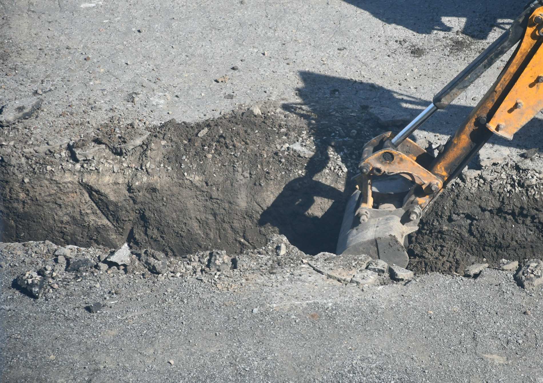 Kaivinkoneen kauha kaivaa kaivantoa sorapohjaan.